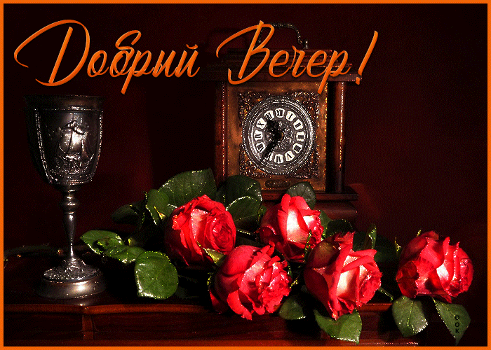 Открытка с пожеланием приятного и доброго вечера с букетом ярко красных роз на столе.