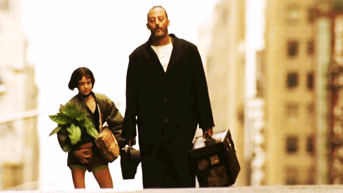 Живая gif картинка со знаменитой сценой из Фильма Леон, Жен Рено идёт с чемоданами, а Натали Портман (Матильда) с цветками.