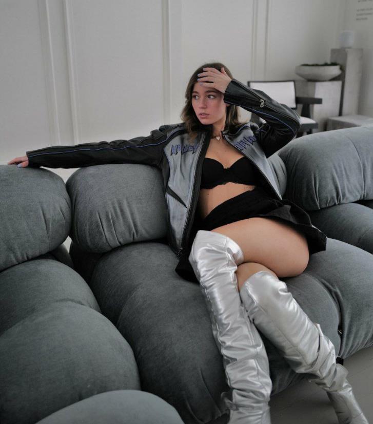 А тут она лежит на диване в высоких серебряных сапогах, мини юбке и чёрном лифчике. А тут она лежит на диване в высоких серебряных сапогах, мини юбке и чёрном лифчике.