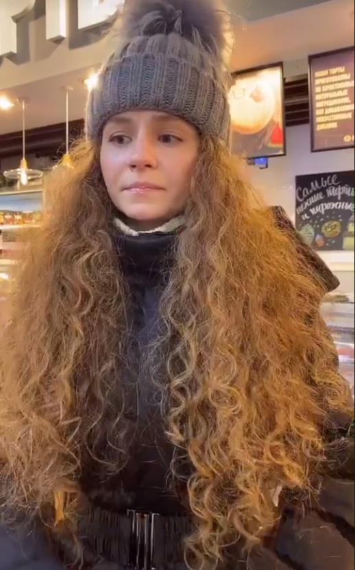 Жена Кудрявая в зимней шапке с помпоном.