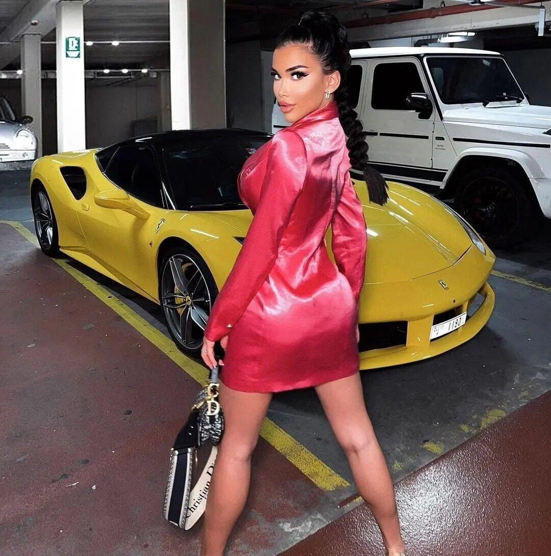 Фото бывшей Дурова на фоне дорогой жёлтой машины в коротком красном платье.