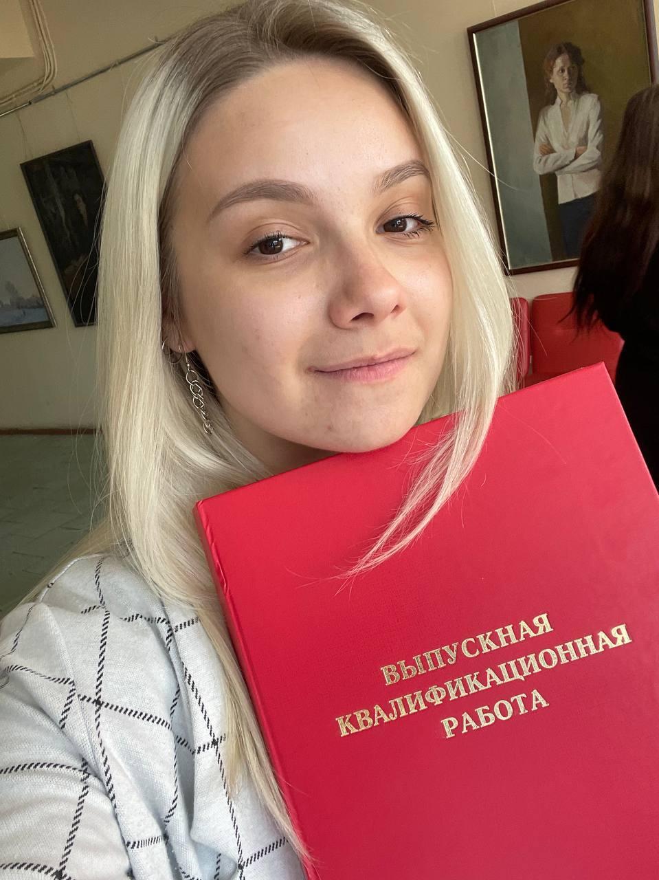 На это фото Аля показывает свою выпускную работу.
