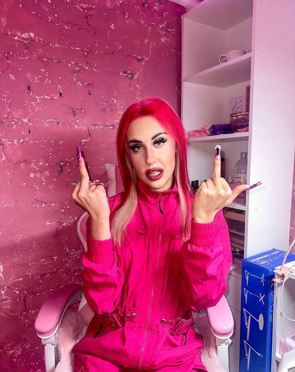 А тут она с ярко красными волосами и таком же костюме, показывает неприличные жесты. А тут она с ярко красными волосами и таком же костюме, показывает неприличные жесты.