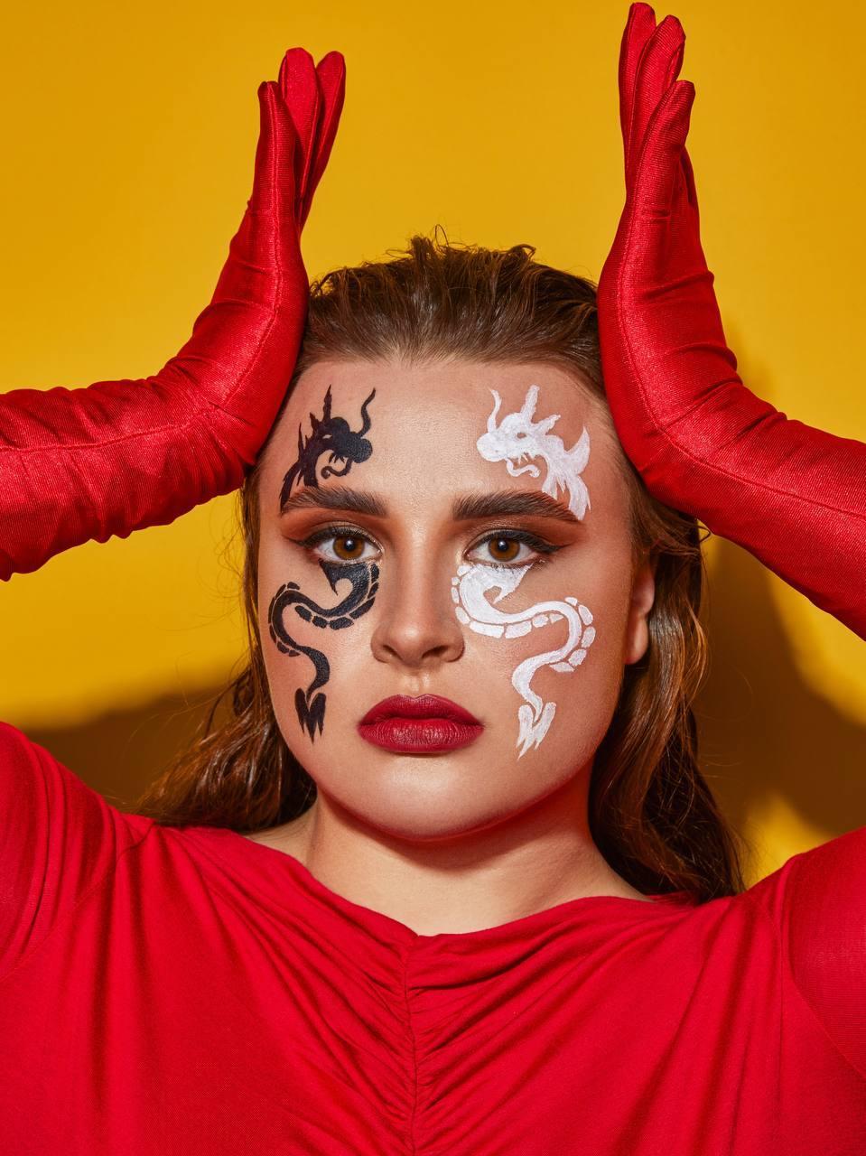 Красивый снимок лица "Вероны" крупным планом с татуировками драконов в стиле Инь и Янь. Красивый снимок лица "Вероны" крупным планом с татуировками драконов в стиле Инь и Янь.