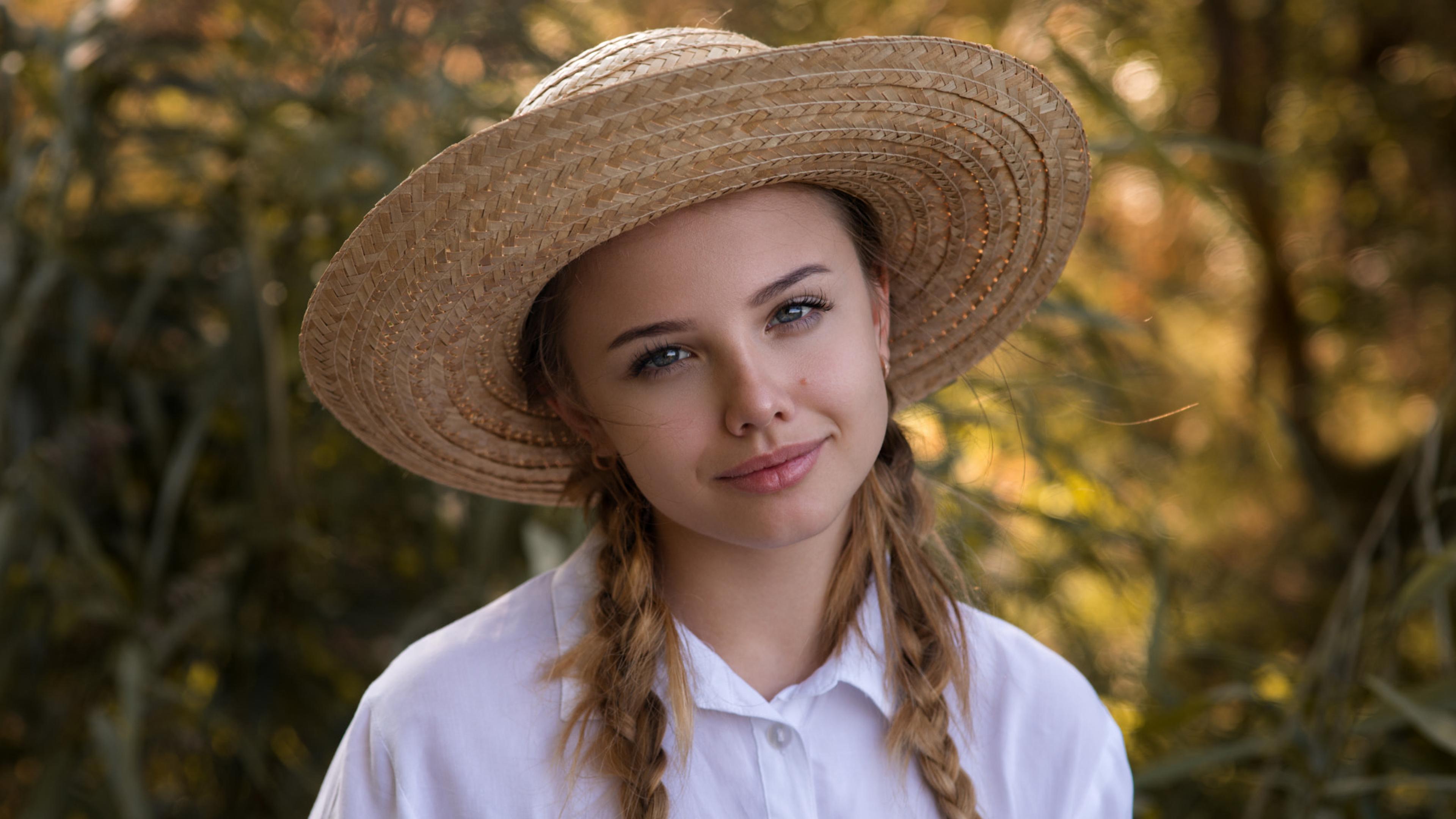 Обои Красивая молодая девушка в соломенной шляпе.