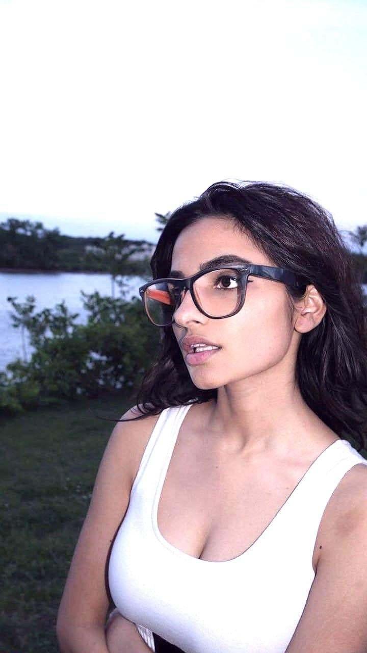 Брюнетка Фарха Халиди в очках и белой майке. Брюнетка Фарха Халиди в очках и белой майке.