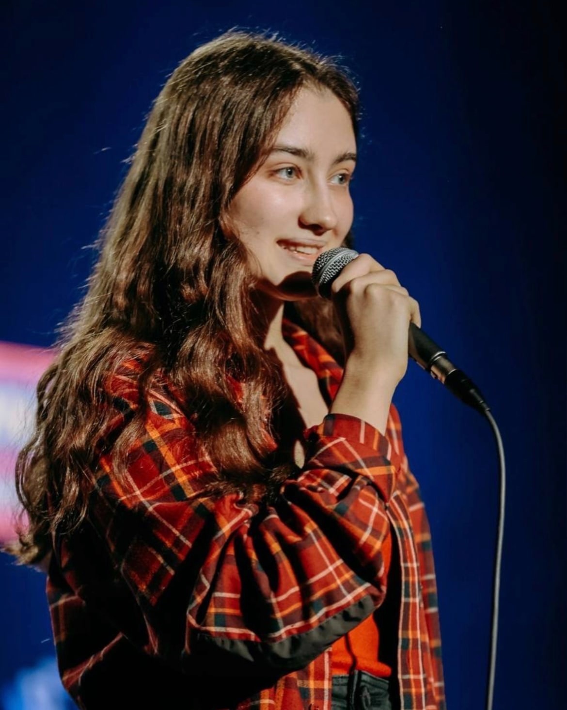 Динара в красной рубашке в клетку во время своего выступления. Динара в красной рубашке в клетку во время своего выступления.