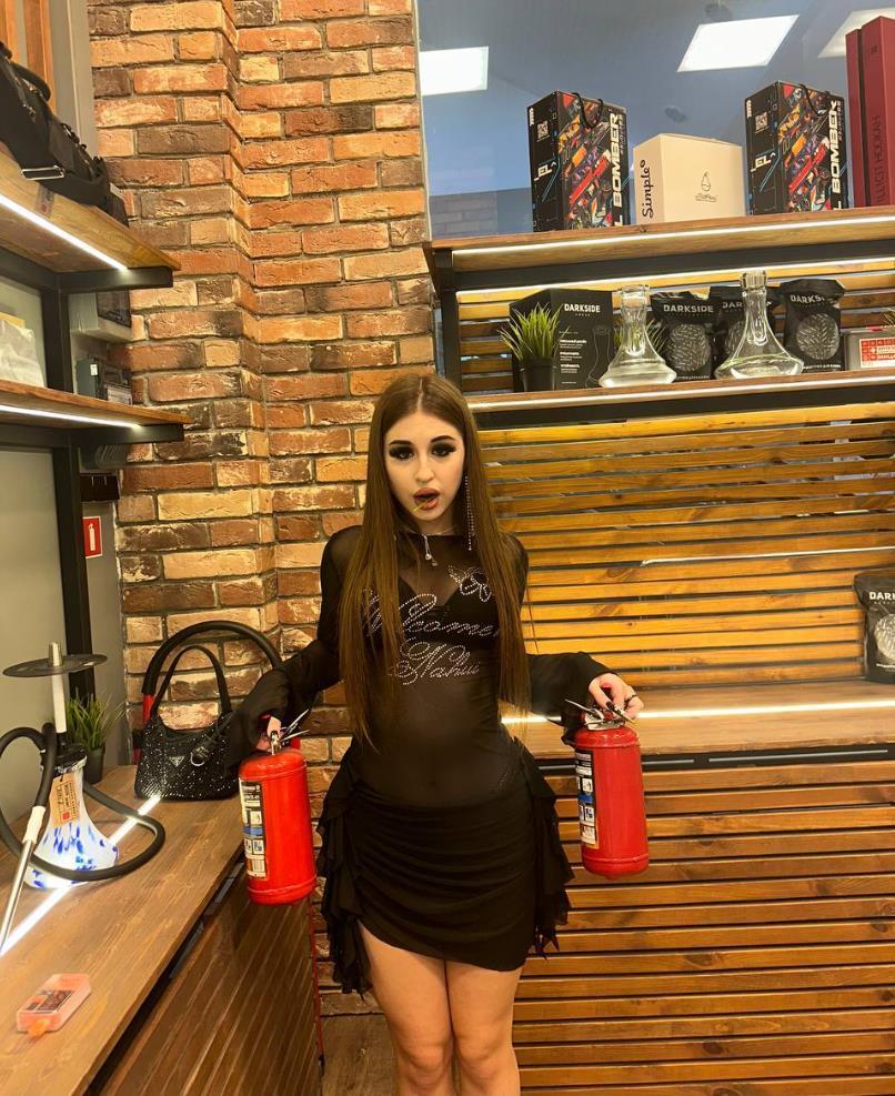 Смешной снимок Эвелин в чёрном лифчике с красными огнетушителями. Смешной снимок Эвелин в чёрном лифчике с красными огнетушителями.