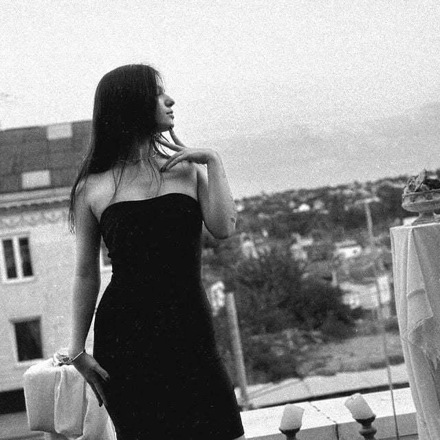 Чёрно-белый снимок "kspersss" на крыше дома в обтягивающем чёрном платье. Чёрно-белый снимок "kspersss" на крыше дома в обтягивающем чёрном платье.