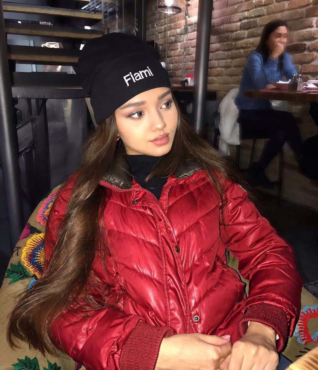 Стильная фотка из кафе в красной куртке и шапке с надписью "Fiami". Стильная фотка из кафе в красной куртке и шапке с надписью "Fiami".