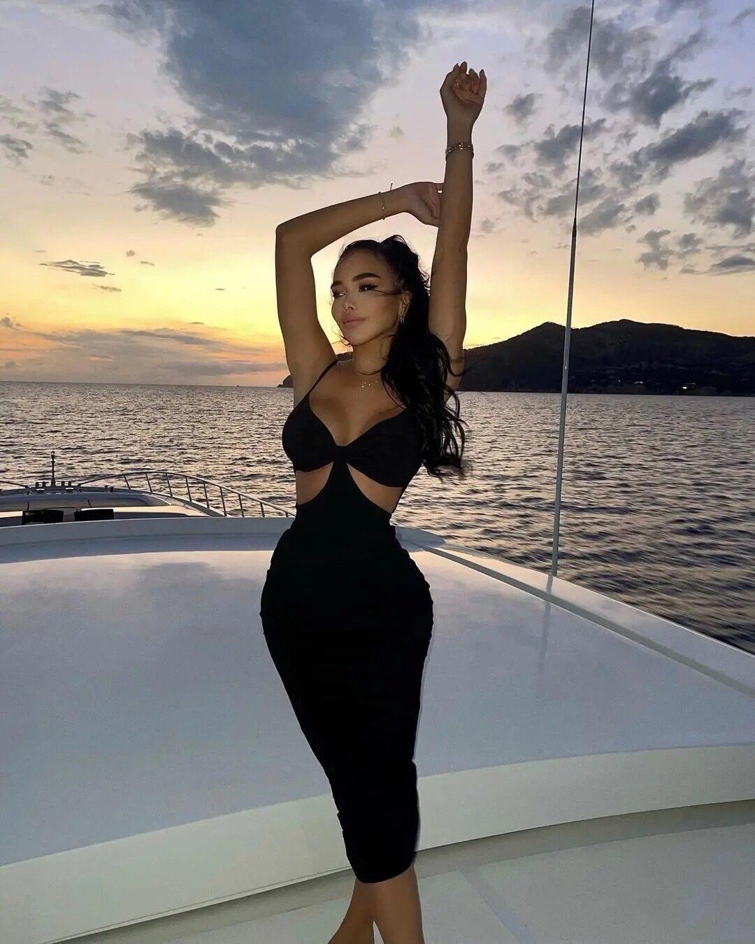 Кадр на фоне заката на яхте в чёрном вечернем платье.