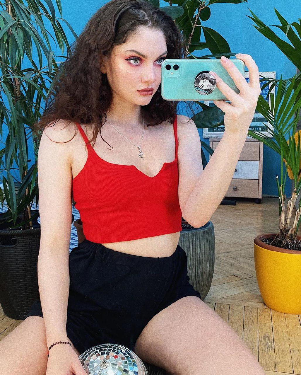 Зарыковская делает селфи в красном топе и синих шортах. Зарыковская делает селфи в красном топе и синих шортах.