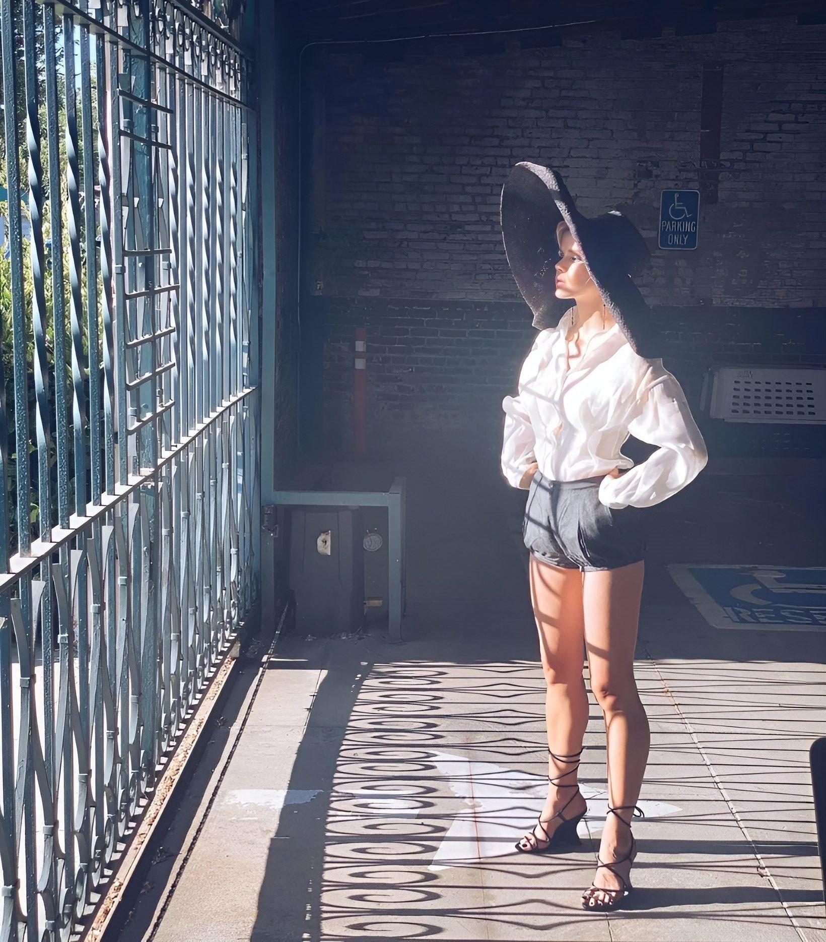 Креативное фото в огромной чёрной шляпе.