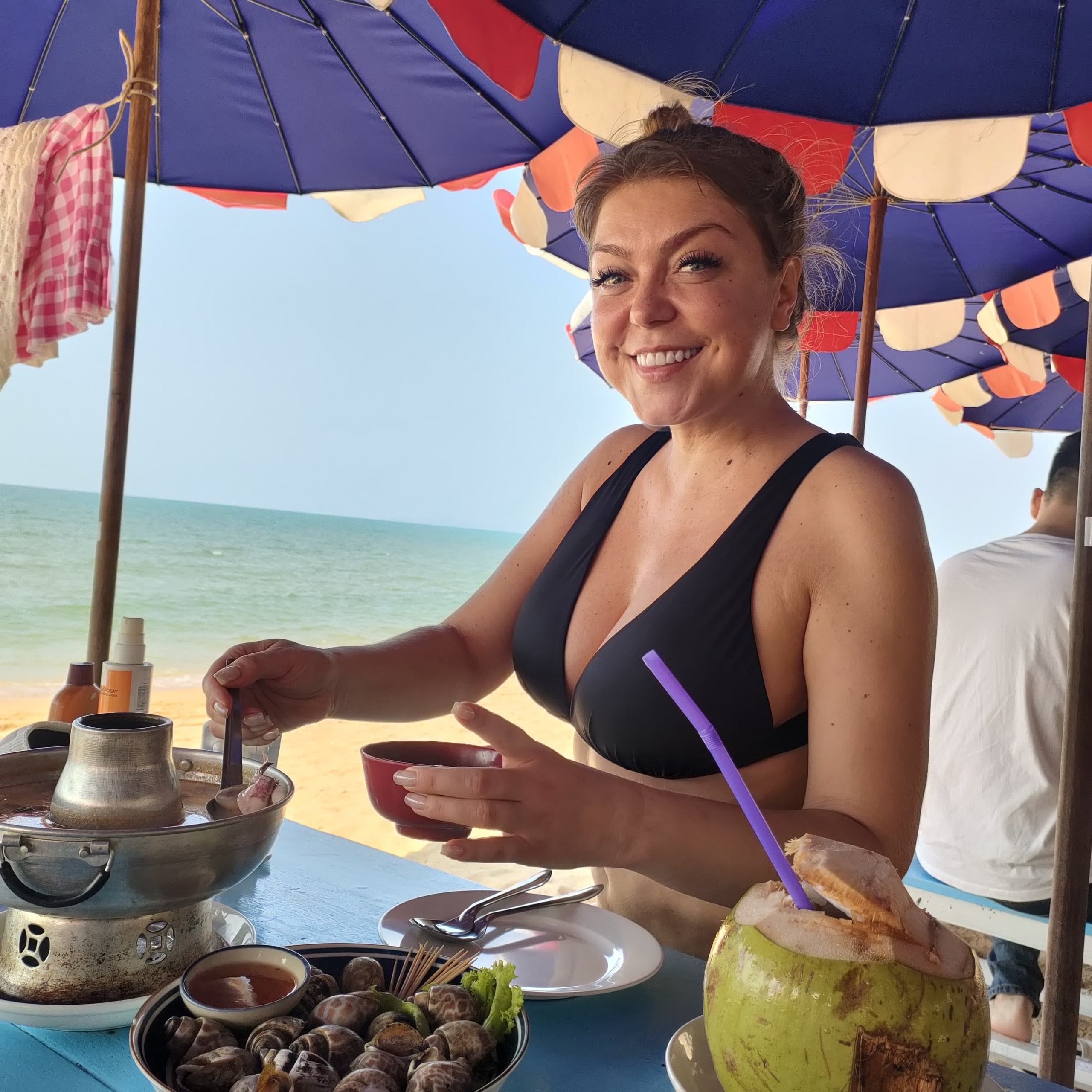 Улыбающаяся Попеча на отдыхе без макияжа в чёрном лифчике от купальника.