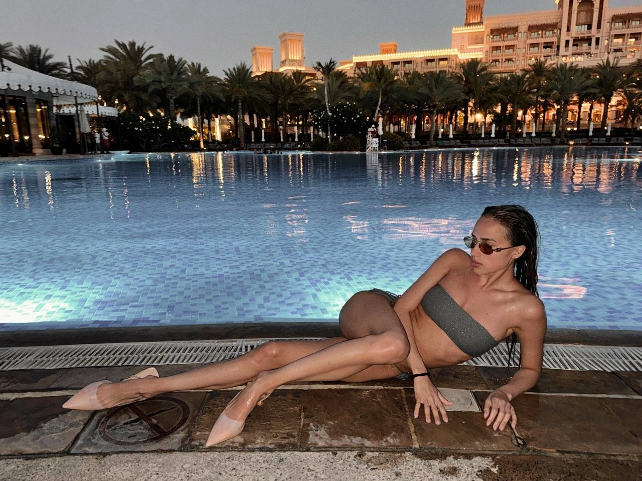 Вечерний снимок с Загитовой на фоне бассейна и пальм в купальнике. Вечерний снимок с Загитовой на фоне бассейна и пальм в купальнике.