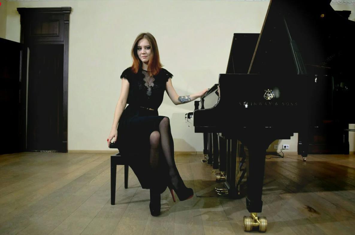 Красивый кард за роялем в чёрном платье и чулках. Красивый кард за роялем в чёрном платье и чулках.