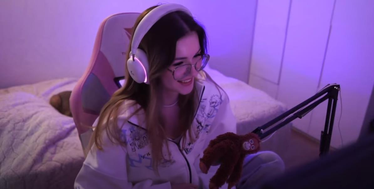 Скриншот со стрима eevochka в наушниках перед микрофоном.