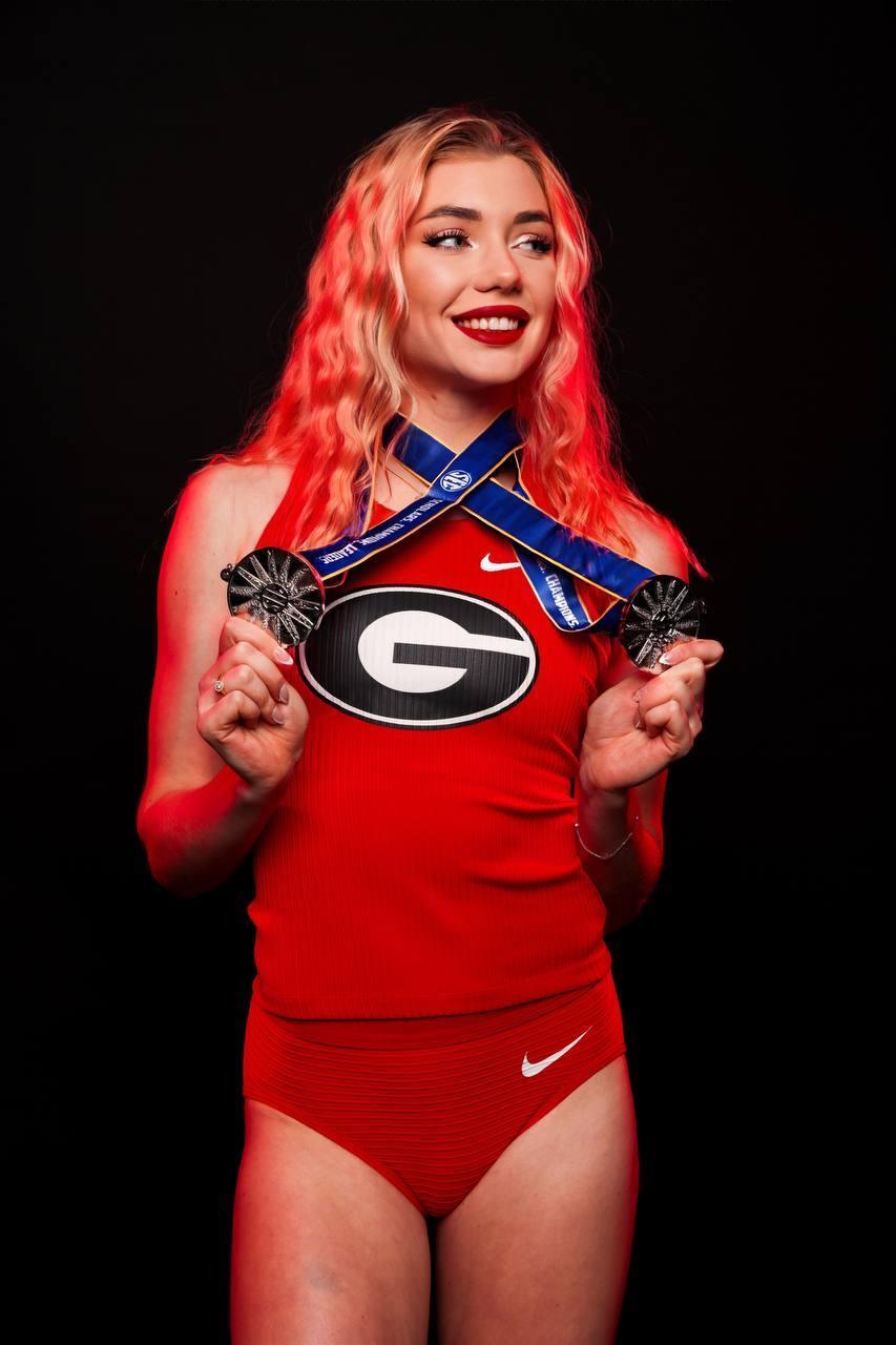 Классный снимок нашей блондинки с медалью в красной майке и спортивных трусах на чёрном фоне. Классный снимок нашей блондинки с медалью в красной майке и спортивных трусах на чёрном фоне.