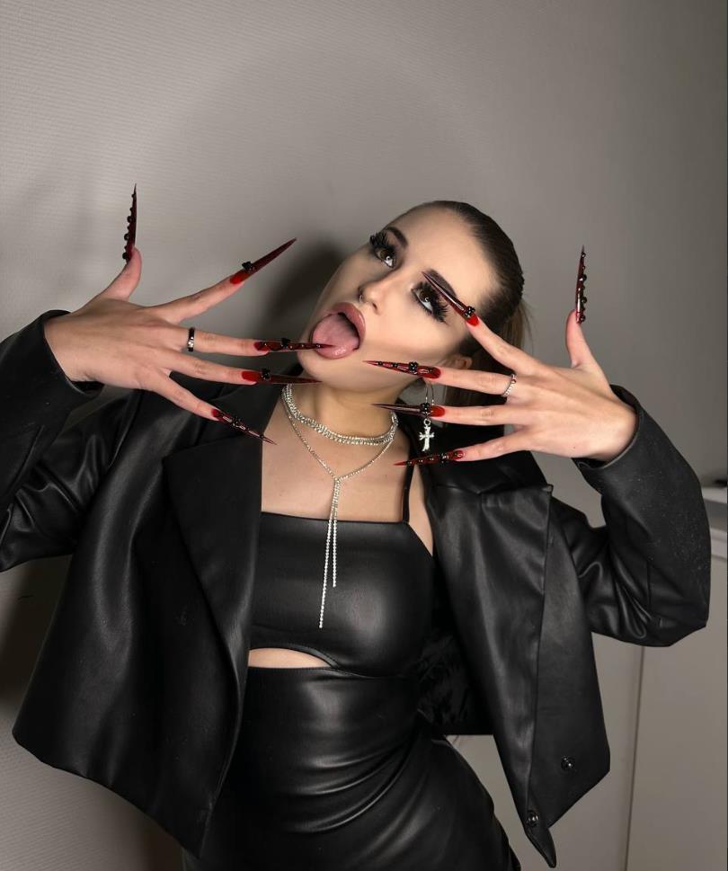 Крутой снимок Эвелин с высунутым языком и огромными красными ногтями. Крутой снимок Эвелин с высунутым языком и огромными красными ногтями.