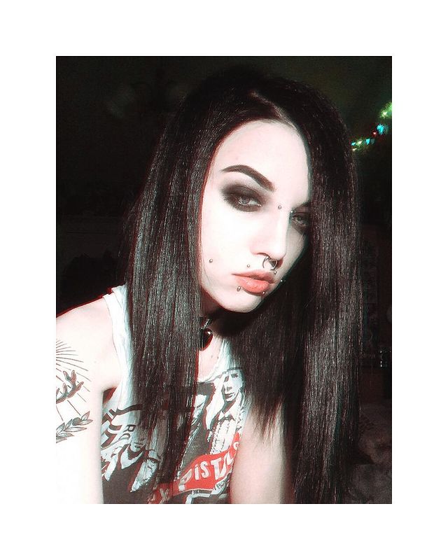 Красотка vikanus в чёрном готическом образе с пирсингом по всему лицу.