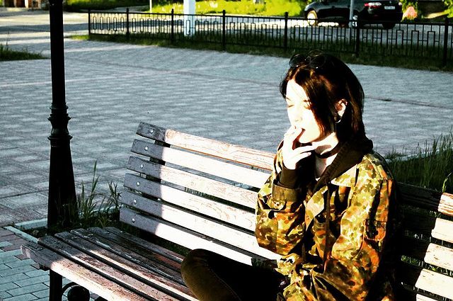 А на этом снимке она курит на лавочке.