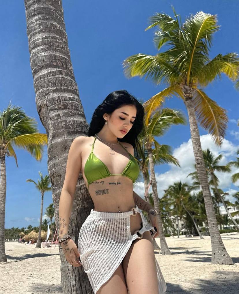 Красивое фото с Katteyes у пальмы в зелёном лифчике от купальника.