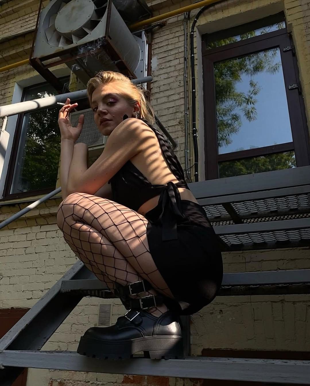 На этом фото Карина Александрова курит в короткой мини юбке и чулках в сетку.